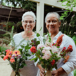 Two seniors holding a bouquet