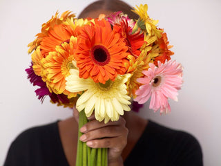 Woman holding flowers in front of her face