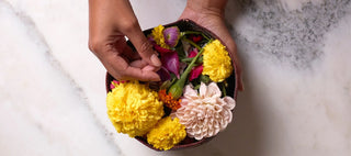 Black hand holding a bowl of flowers