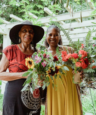 Two black senior woman holding flower bouquets
